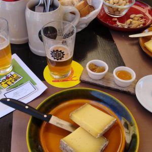 voll belegter Tisch mit Käse und Bier in einer Genuss-Station