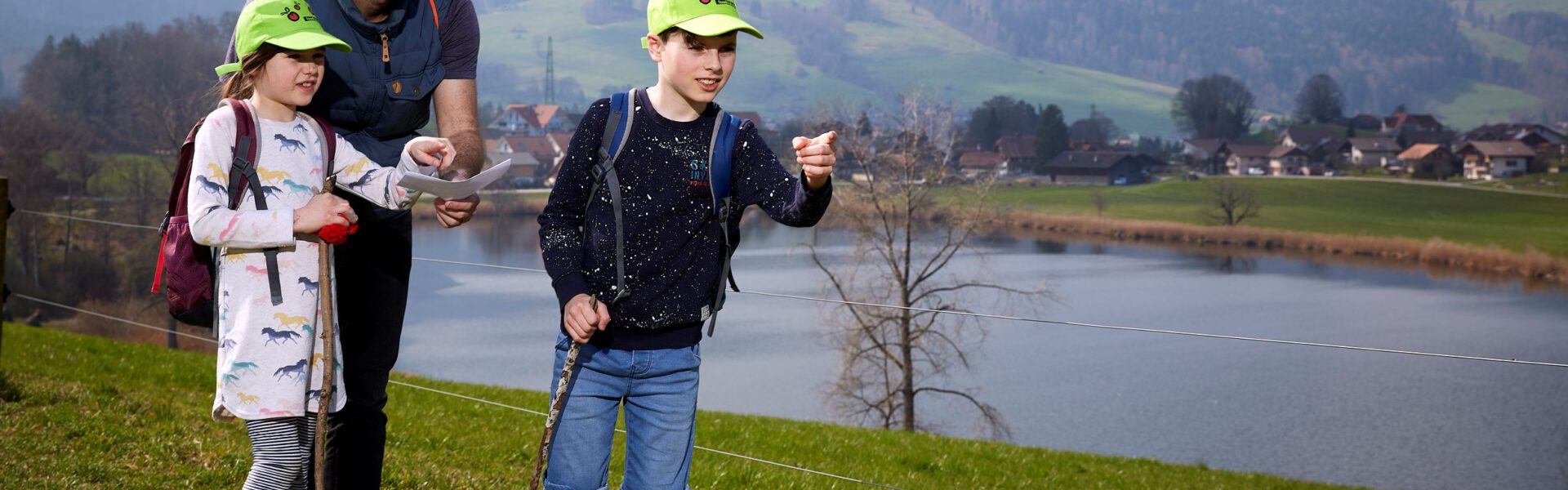 Bild Naturpark Gantrisch an einem Weiher, Kinder und Erwachsene errätseln den Weg